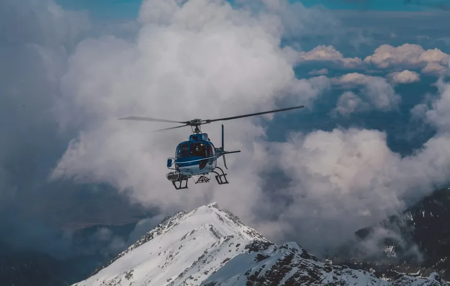 Hélicoptère bleu en vol au-dessus des nuages